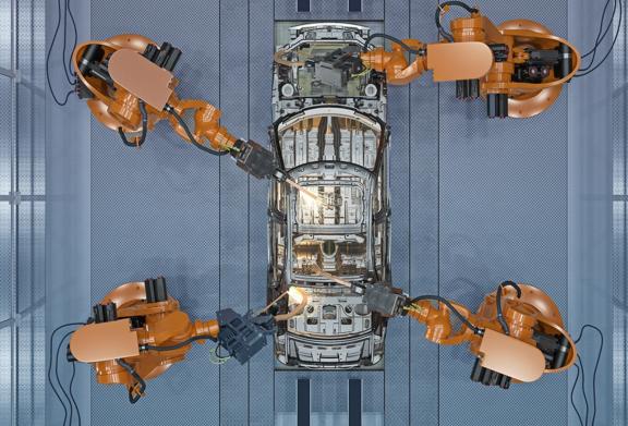 Robotic arms assembling a car in an automated manufacturing facility, showcasing advanced industrial automation