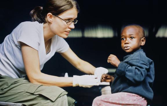 Healthcare worker providing medical assistance to a young child during a humanitarian mission.


