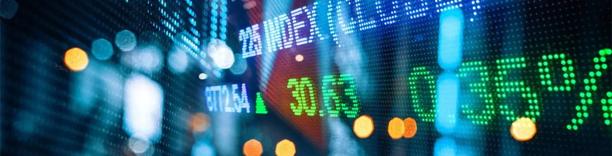 Digital stock market display showing financial data, index values, and percentage changes in green and white text.