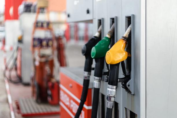 Close-up de bombas de combustível com bicos coloridos em posto de gasolina