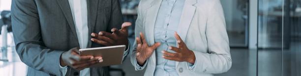 Two business professionals in suits discussing strategy, symbolizing leadership and corporate planning