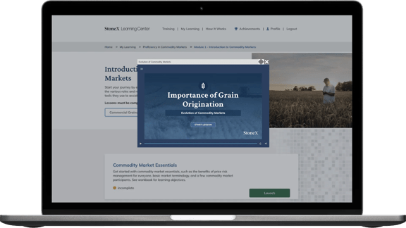 StoneX Learning Center website displayed on a laptop screen showcasing training programs and market intelligence.
