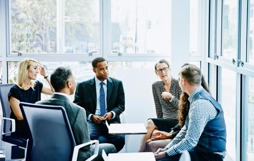 Grupo diversificado de profissionais de negócios discutindo em um salão de escritório moderno e bem iluminado