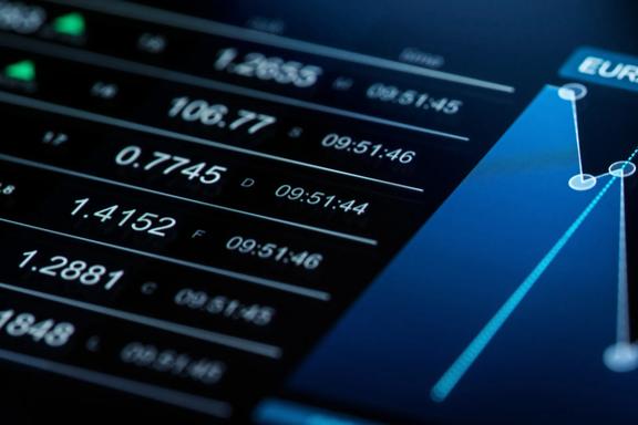 Close‑up of a digital trading interface showing currency prices and a line chart on a dark screen.