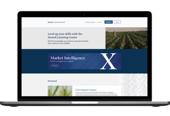 Site do StoneX Learning Center exibido em uma tela de laptop com programas de treinamento e inteligência de mercado.