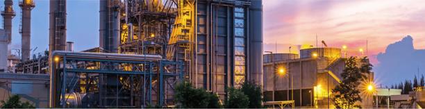 Industrial oil refinery with towers at sunset, representing energy sector infrastructure