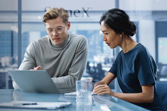 StoneX employees working at laptop in StoneX office 