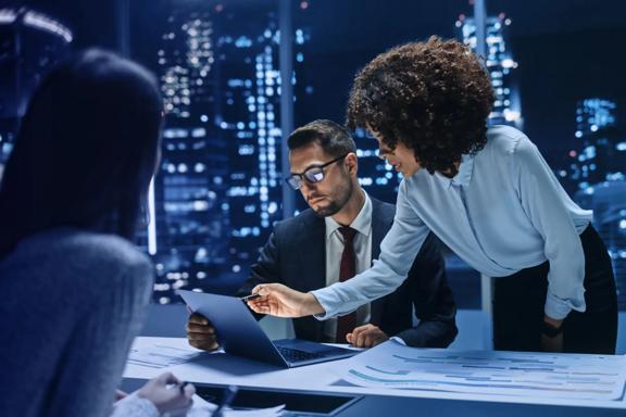Team of professionals reviewing financial data during an evening strategy meeting