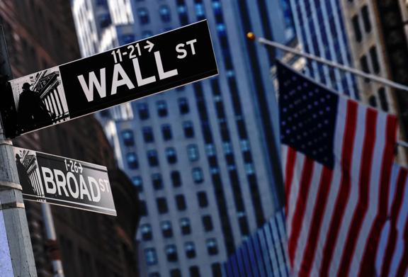 Wall Street and Broad Street signs in New York City's Financial District with American flag