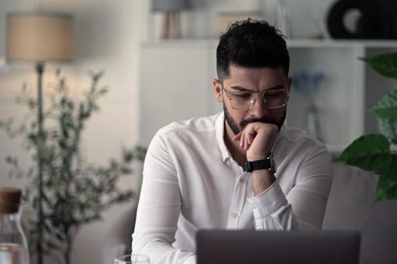 A prospective client sitting at home while observing the markets on their laptop