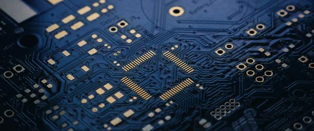 Close-up view of a blue printed circuit board with electronic pathways and components