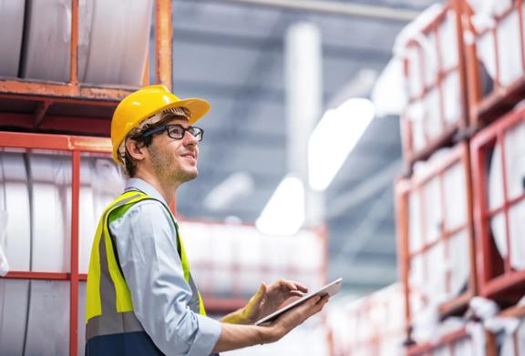 Warehouse worker using a tablet to monitor inventory in a storage facility