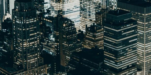 City financial district at night featuring illuminated skyscrapers and commercial office towers