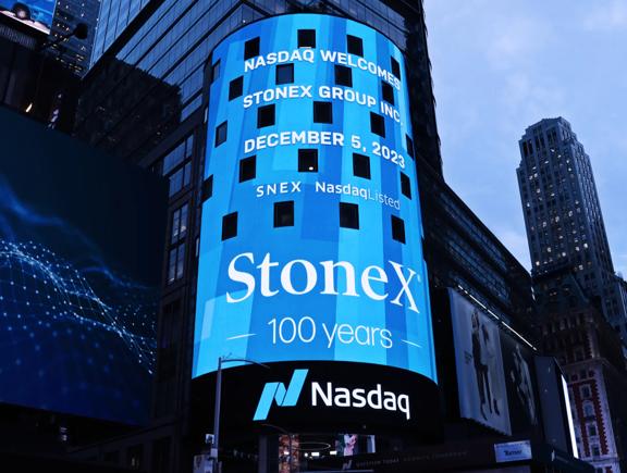 StoneX branding displayed on Nasdaq digital billboard in a city at night
