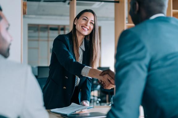 Smiling businesswoman shaking hands during a professional meeting in a modern office