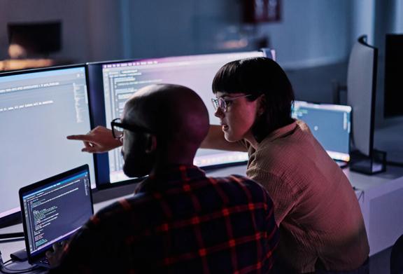 Man and woman looking at multiple computer screens