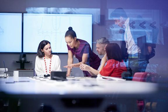 Team of diverse professionals having a business meeting and collaborating around a table in a modern office