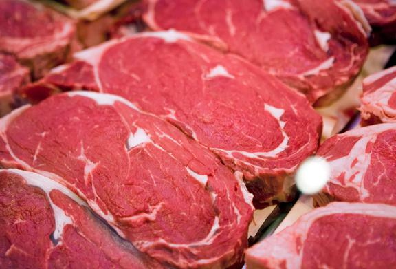 Close-up of fresh raw beef ribeye steaks on display at a butcher counter