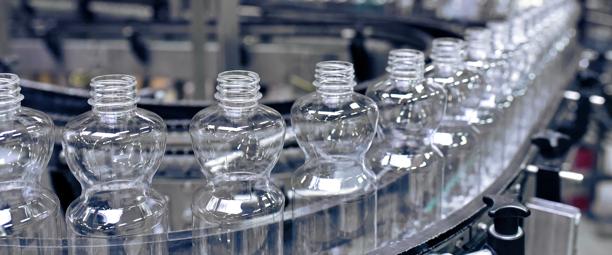 Close-up of plastic water bottles on a conveyor belt in a manufacturing plant