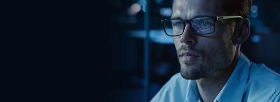 Professional man wearing glasses in dark office