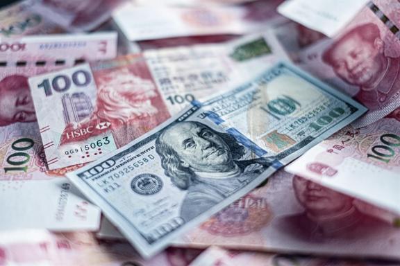 Pile of US 100 dollar and Chinese 100 yuan banknotes