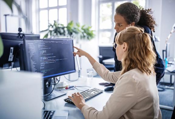 Colleagues working together at a desk with digital tools	