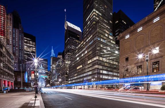 Busy New York City street at night with light trails and illuminated skyscrapers