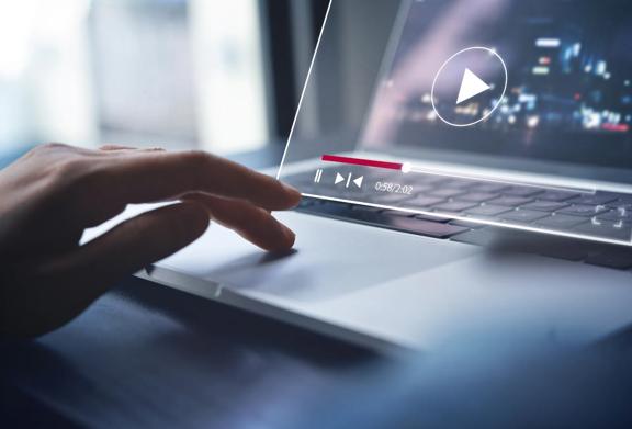 Close-up of a hand using a laptop with a video player interface overlay on the screen