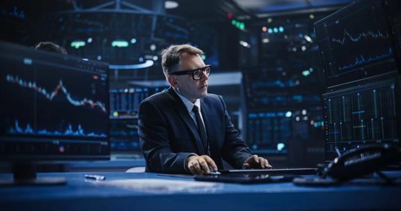 Finance professional working at computer in dark office