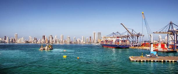 Panoramic view of a busy harbor with cranes, ships, and modern city skyline in the background, showcasing maritime trade and infrastructure.