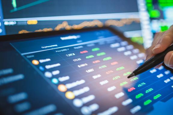 Close-up of a digital trading platform displaying market data, asset prices, and performance metrics on a tablet screen.