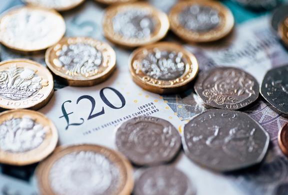 Close-up of British pound coins and £20 banknote representing UK currency and financial markets