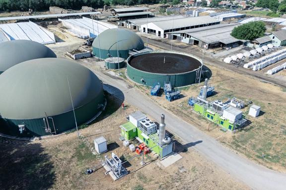 Vista aérea de usina de biogás com tanques de armazenamento e equipamentos de energia em área rural