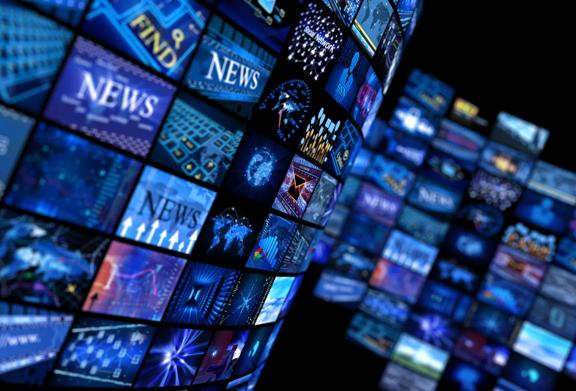 Wall of digital screens displaying news and media content in a high-tech environment