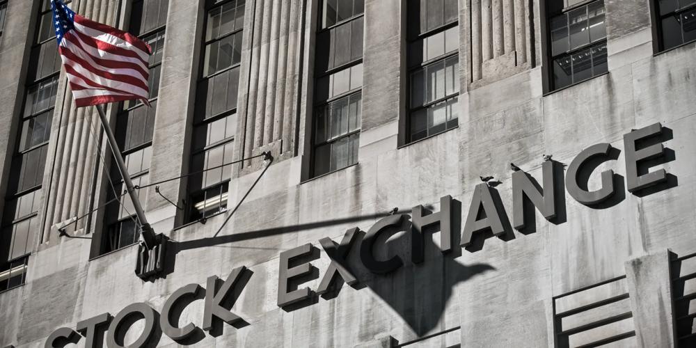 Stock exchange building facade with a United States flag and prominent stock exchange signage, representing financial markets, equity trading, and capital investment.