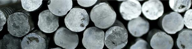 Aluminum or steel billets stacked together, representing industrial metals and raw material supply