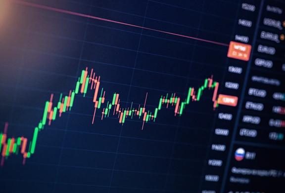 Close-up of a candlestick chart showing stock price movement and trading volume on a digital screen
