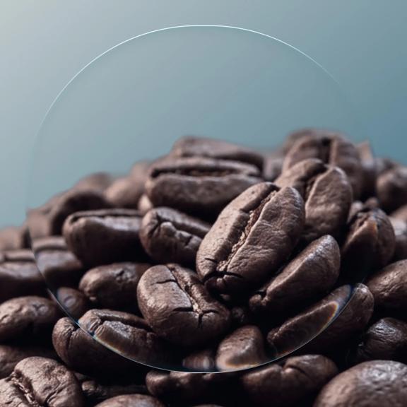Close up view of roasted coffee beans with a magnified section highlighting texture and detail, representing coffee commodity trading, agricultural markets, global supply chains, and soft commodity investing.