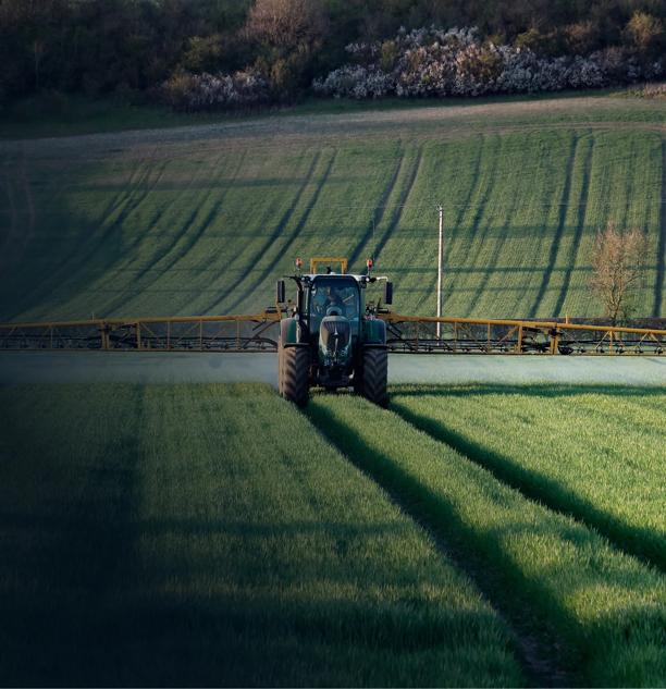 Tractor working across a large agricultural field.