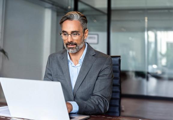 Professional working on a laptop in a modern office meeting room