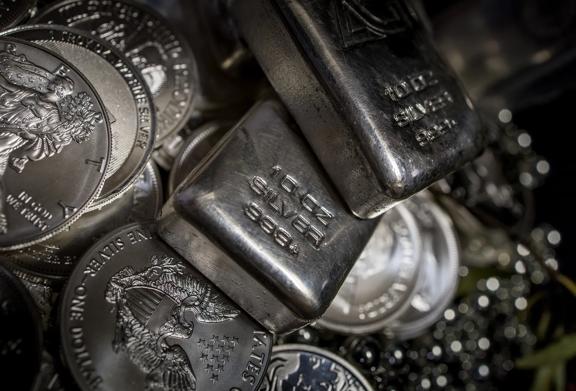 Close-up of silver bullion bars and coins showing 1 oz fine silver 999.4 engraving