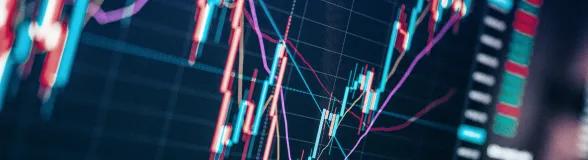 Close-up of a digital stock market chart showing colorful candlestick patterns, trend lines, and price movements on a dark background