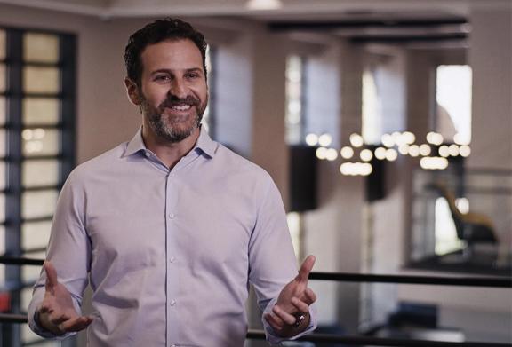 Business professional speaking during an interview or presentation in a modern corporate office setting