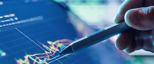 Hand holding pen pointing at financial chart