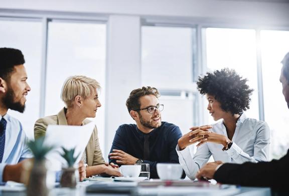 Equipe de negócios diversificada tendo uma discussão colaborativa em um ambiente de escritório moderno.
