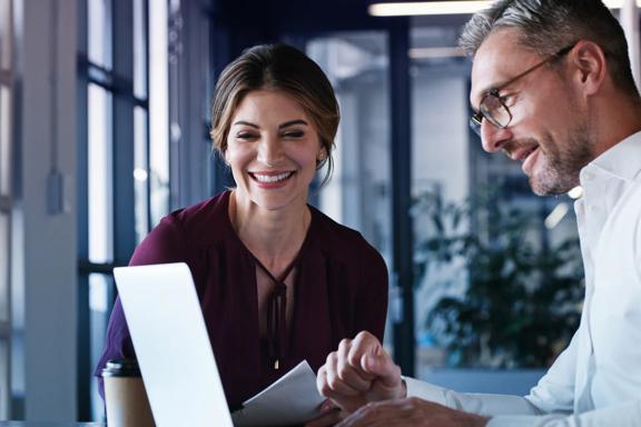 Finance professional sitting down with a client in an office setting