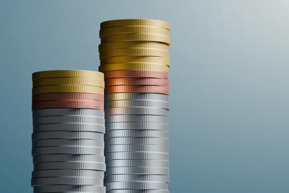 Two stacks of gold, copper, and silver coins on a teal background
