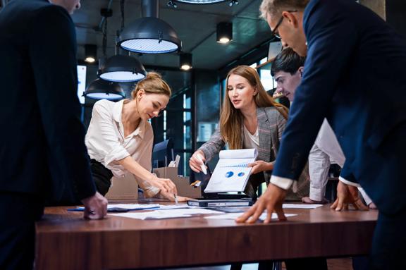Corporate team analyzing data and discussing strategy in a modern office setting