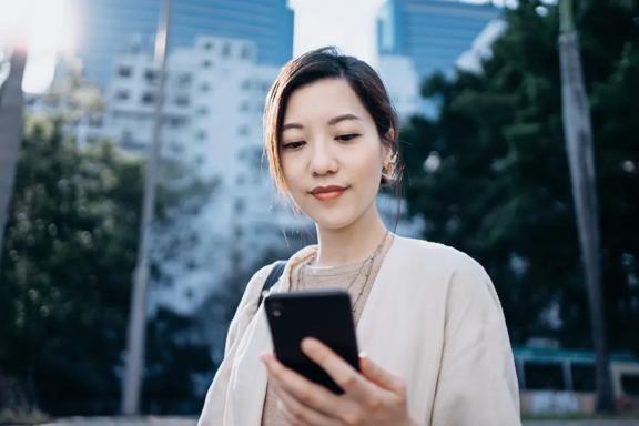 Person viewing investment information on a mobile phone