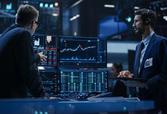 Professional men looking at multiple screens